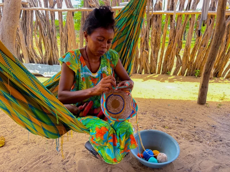 Tejedora elaborando base redonda con hilo de colores intensos