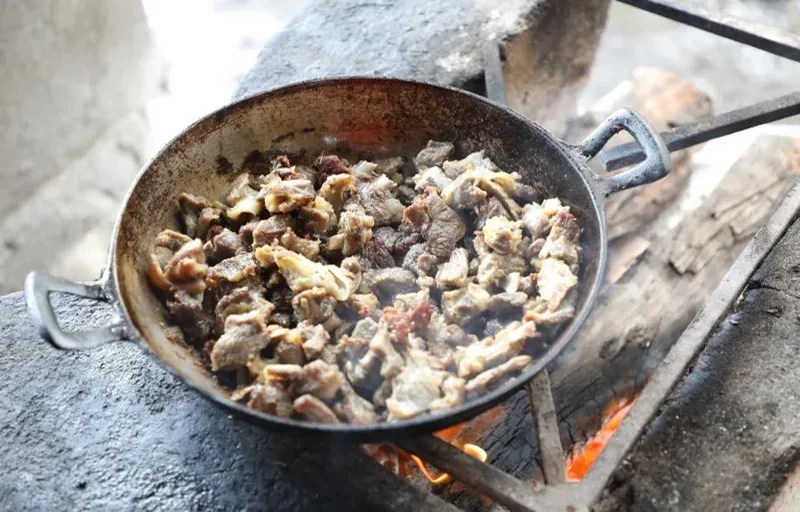 Friche de chivo cocinado sobre leña en fogón típico de ranchería