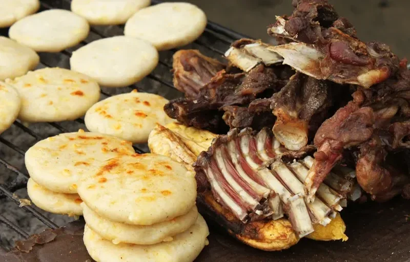 Friche de chivo y arepas doradas sobre carbón en una ranchería tradicional Wayuu