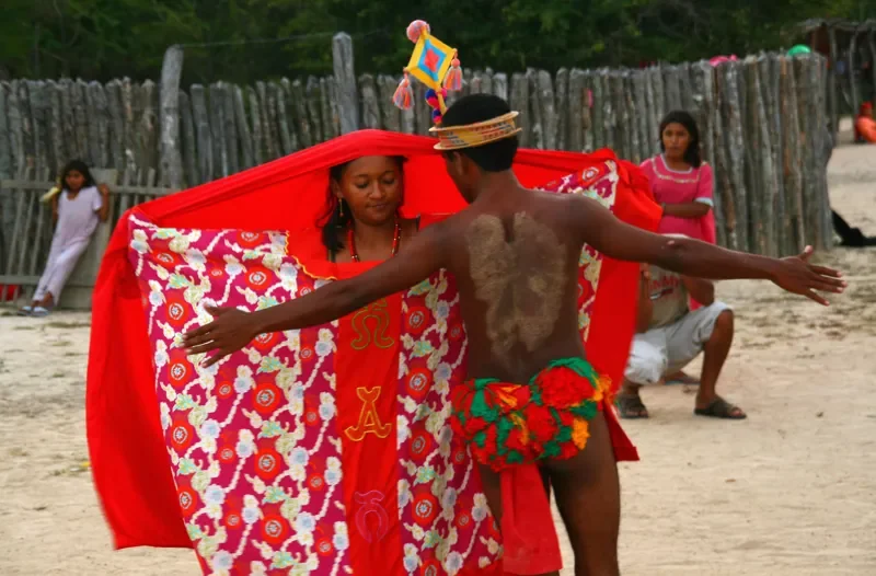 Pareja wayuu realizando danza tradicional con manta roja