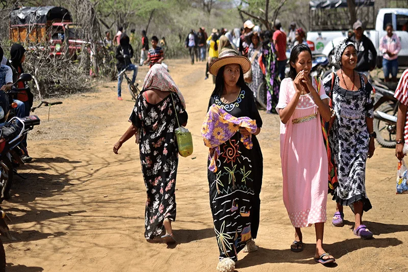 Grupo de mujeres caminando en comunidad Wayuu, cada una con actitud distinta ante la cámara