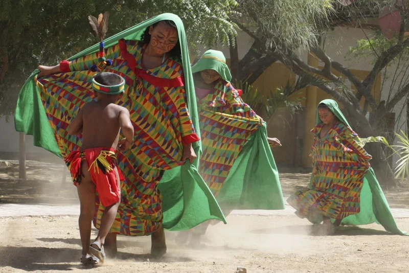 Niño participando en danza tradicional junto a mujeres en espacio Wayuu