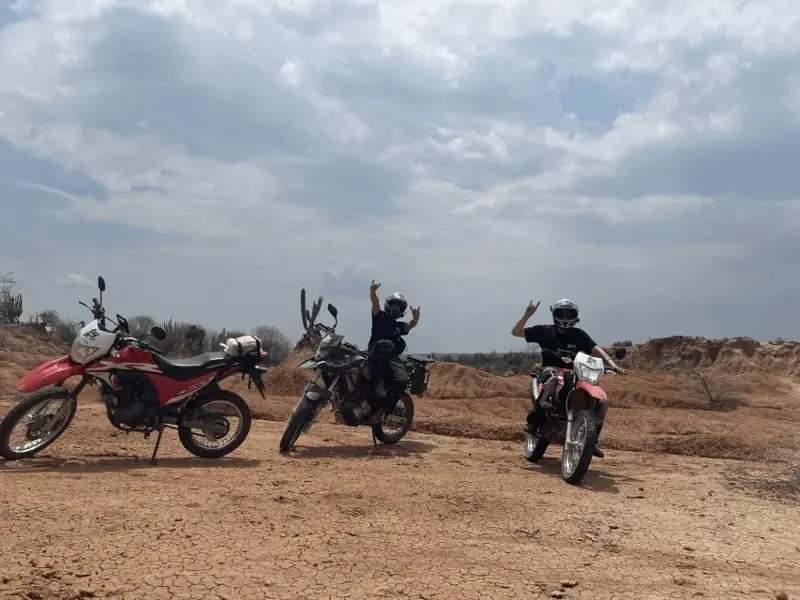 Guías en motocicletas recorriendo caminos desérticos en La Guajira, apoyo clave en seguridad y orientación