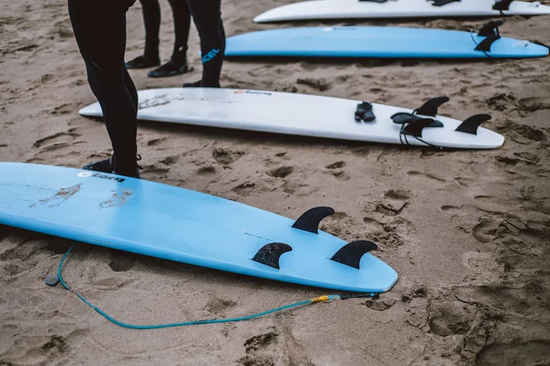 Tablas de surf alineadas en la arena antes de una clase práctica con instructores