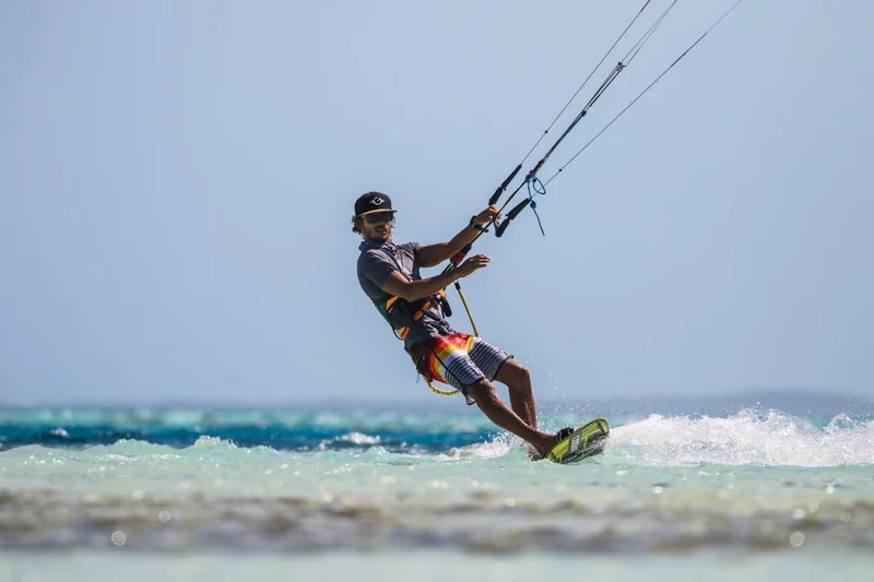 Kitesurfista navegando sobre aguas turquesas en un destino del Caribe colombiano con viento constante