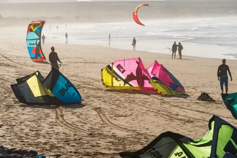 Kitesurfistas alistando sus cometas en una playa de viento constante en La Guajira