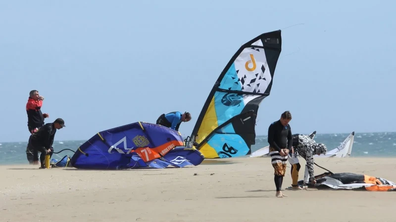 Personas preparando cometas en la playa para practicar kitesurf en La Guajira