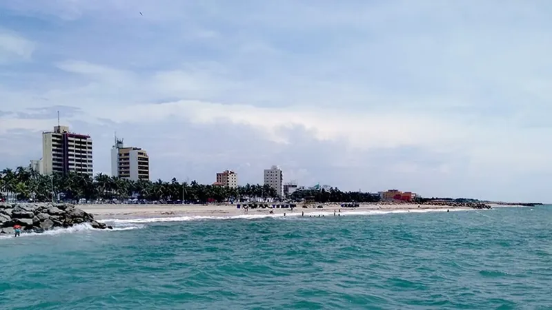 Vista panorámica de la costa de Riohacha con edificios y playa activa en primer plano