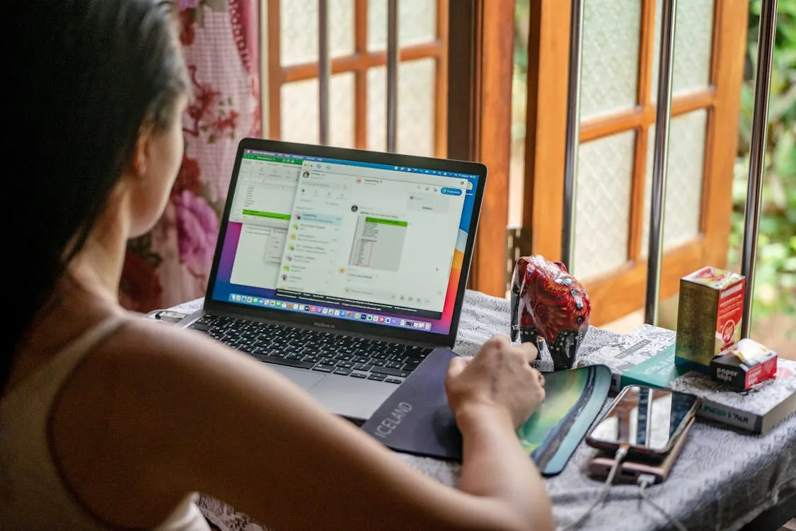Mujer trabajando remoto desde escritorio junto a ventana en Riohacha